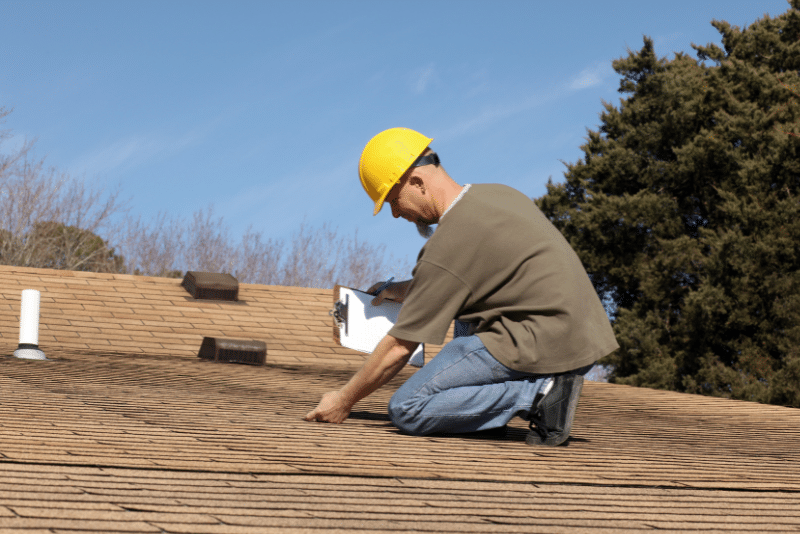 Roofing contractor inspecting a residential roof before an insurance claim