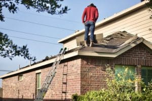 Roof inspector examining storm damage during an insurance roof inspection